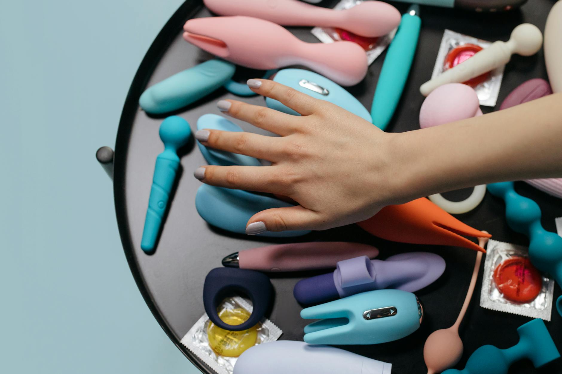 A couple standing together indoors, holding a blue vibrator, symbolizing modern intimacy and shared exploration.