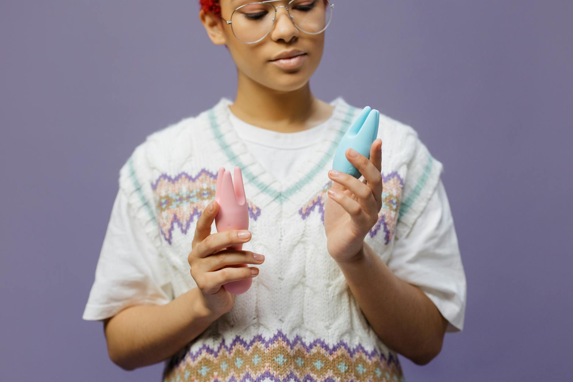 Woman holding blue silicone vibrator, contemplative and confident in her sexuality